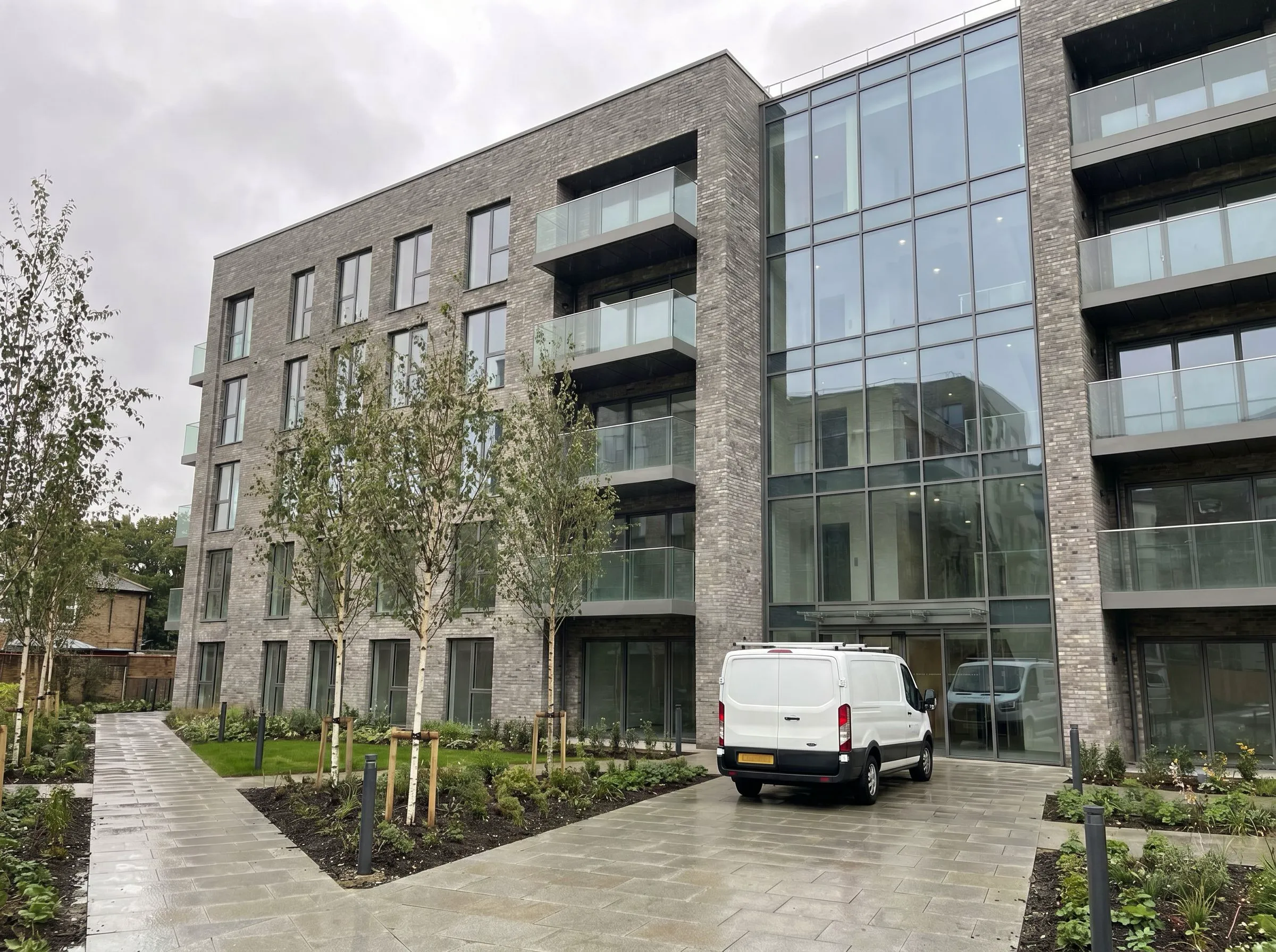 Modern London new build development with after builders cleaning van outside